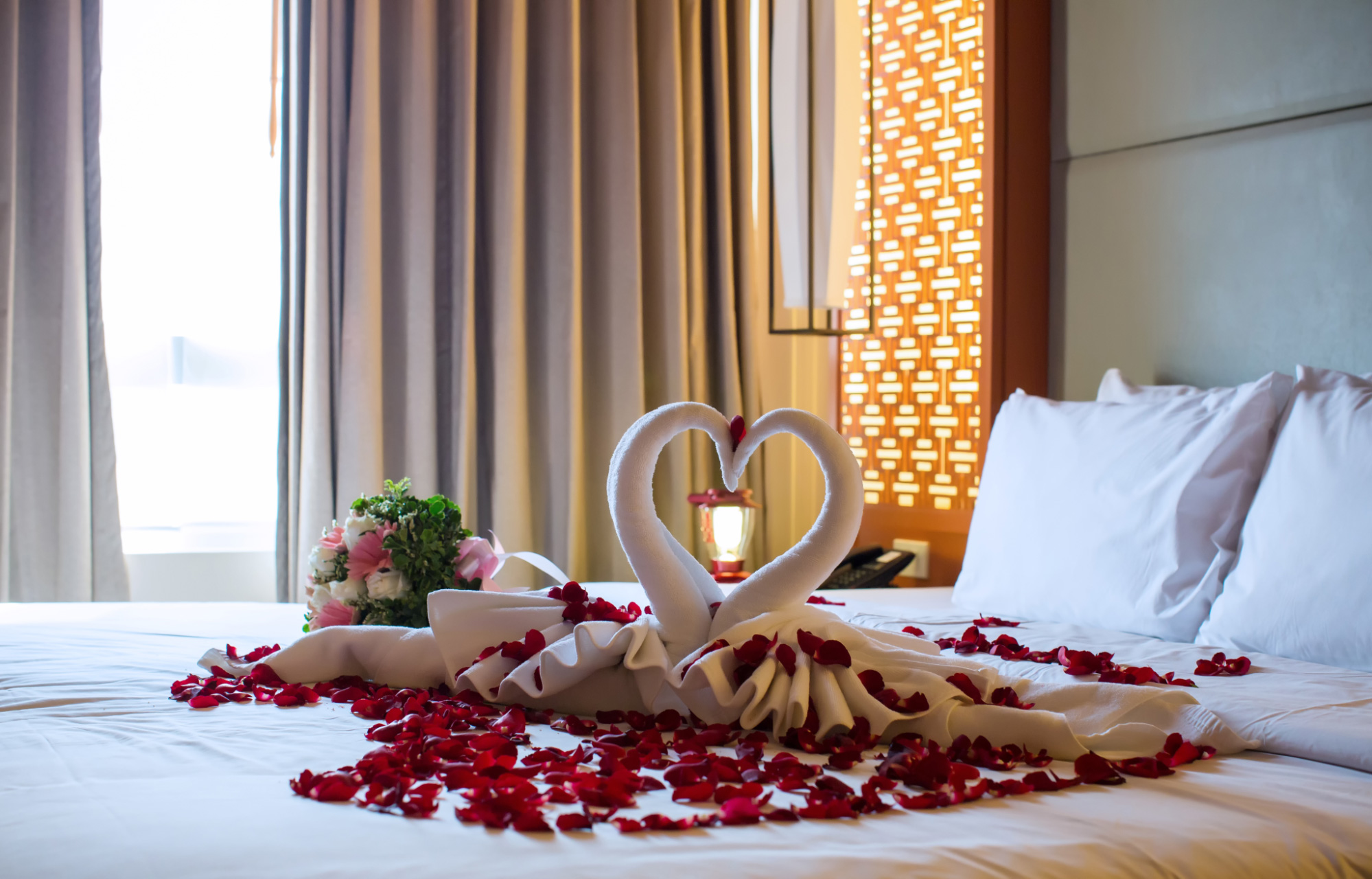 staying at the best private villas in Bali will get a comfortable bed with a sprinkling of red roses on it, making a romantic impression